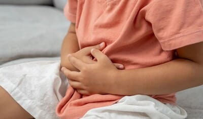 Niño tocando su estómago debido al dolor